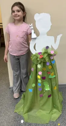 Uśmiechnięta dziewczynka stoi obok pani wiosny.