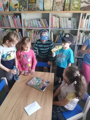 Dzieci bawią się w podchody w bibliotece.