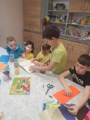 Chłopcy na zajęciach plastycznych sklejają zniszczoną książkę.