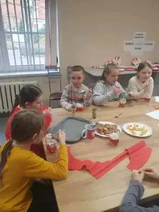 Dzieci zjadają galaretkę z bitą śmietaną.