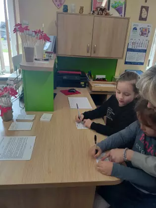 Dziewczynki na zajęciach zapisują nowego czytelnika biblioteki.