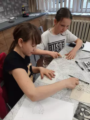 Na zajęciach z rysunku dziewczynki wykonują swoje projekty.