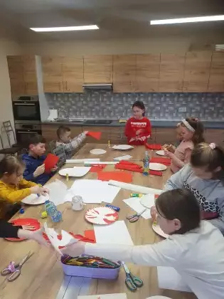 Dzieci tworzą symbole narodowe na papierowych talerzykach.