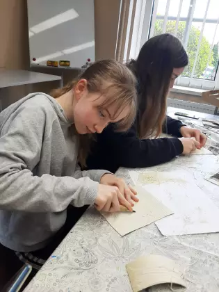 Dziewczyny malują obraz na kartce.