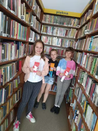 Uczniowie zwiedzają działy biblioteczne.