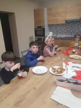 Dzieci zjadają galaretkę z bitą śmietaną.