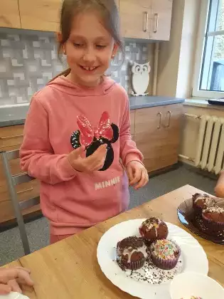 Dziewczynka przygotowuje muffinki jako prezent na dzień Mamy.