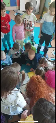 Przedszkolaki uczą się jak posklejać zniszczoną książeczkę.