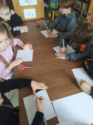 Dzieci tworzą swoje mini książeczki.