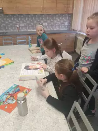 Dziewczynki na zajęciach oglądają książki.