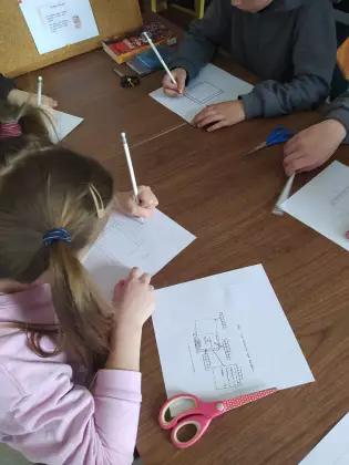 Dzieci tworzą mini książeczki.