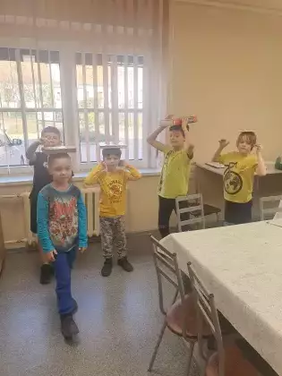 Dzieci na zajęciach ruchowych idą z książką na głowie.