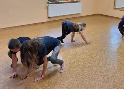 Dzieci chodzą na czworakach po sali treningowej udając psy.