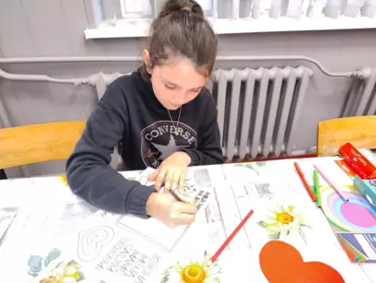 Dziewczynka pisze list do mamy.