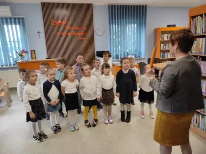 Pani bibliotekarka tłumaczy dzieciom zasady panujące w bibliotece.
