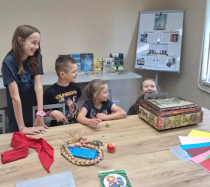 Dzieci losują z kufra atrybuty bohaterów książkowych.