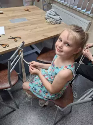 Uczestniczka plecie ze sznurka kwietnik dla mamy