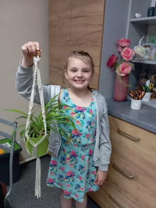 Uczestniczka ze swoim wyplecionym kwietnikiem.