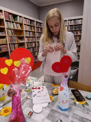 Dziewczynka wykleja serduszko dla mamy.