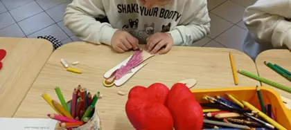 Uczestnik kredkami maluje anioła dla mamy.