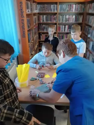 Uczniowie wraz z panią bibliotekarką tworzą kamerę.