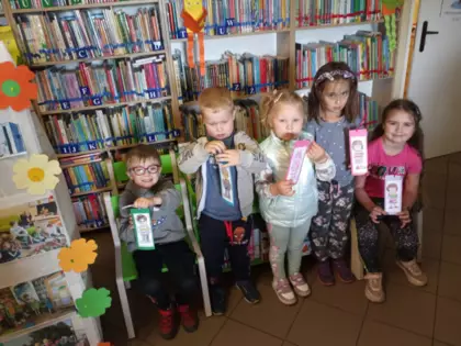 Zdjęcie przedszkolaków z zakładkami w rękach.