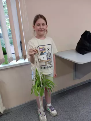 Uczestniczka ze swoim wyplecionym kwietnikiem.