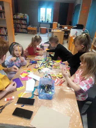 Dzieci w trakcie ronienia papierowych moli książkowych.