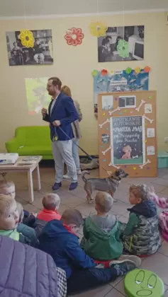 Dzieci siedzą i słuchają prelekcji o Preclu.