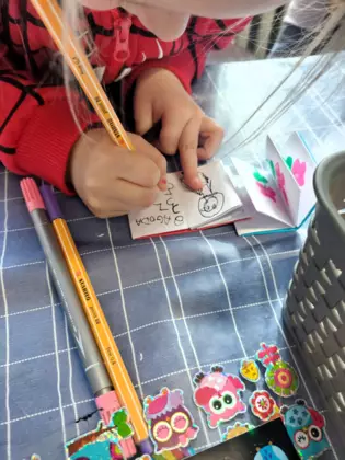 Dziewczynka w trakcie pisania swojej mini książeczki.