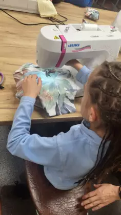 Dziewczynka szyje na maszynie.