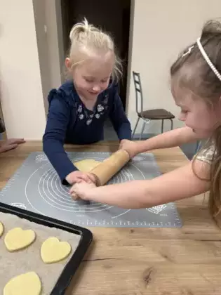 Dziewczynki wałkują ciasto.