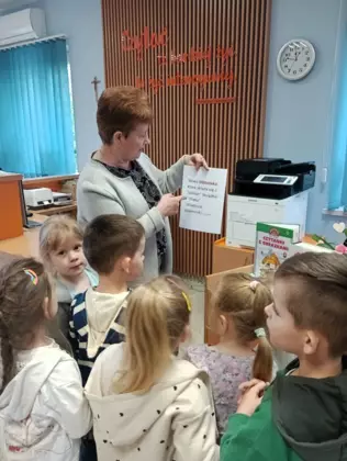 Pani z biblioteki tłumaczy dzieciom co znaczy słowo biblioteka.