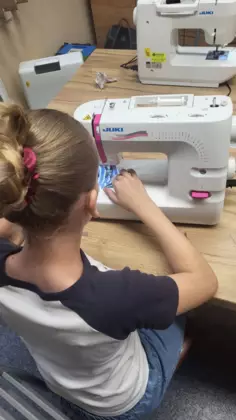 Dziewczynka szyje na maszynie.
