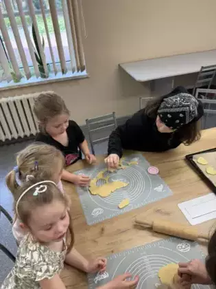 Dziewczynki z ciasta wykrawają serduszka.
