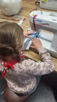 Dziewczynka szyje na maszynie.