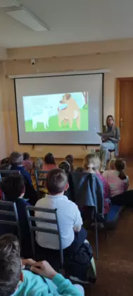 Autorka książki czyta uczniom klasy 1 i 2 książeczki o przygodach pieska.