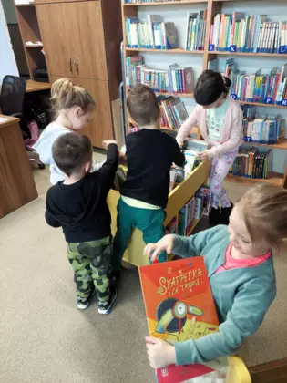 Dzieci poszukują ciekawych okładek książek.