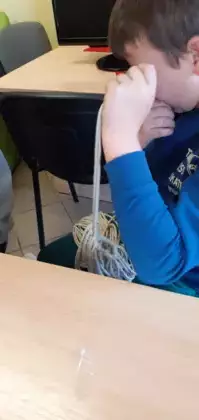 Chłopczyk zwija sznurek.
