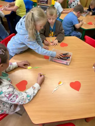 Dzieci kolorują małego drewnanego tulipana.