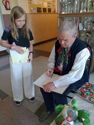 Pan Marek Szołtysek daje swój autograf dziewczynce.