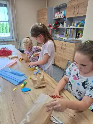 Dziewczynki wykonują koszulę z krawatem jako opakowanie prezentu dla taty.