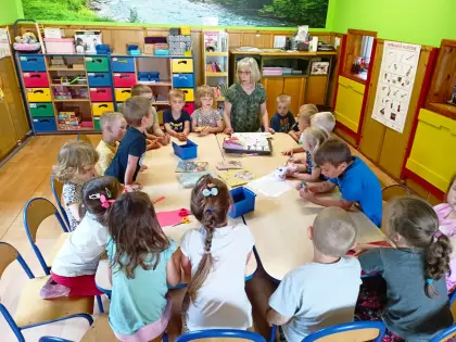 Pani bibliotekarka czyta przedszkolakom książeczki.