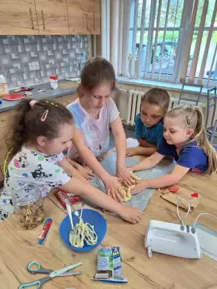 Dzieci mieszają rękami składniki na ciasteczka.