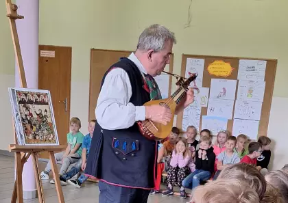 Pan Marek Szołtysek pokazuje instrument przypominający mandolinę.