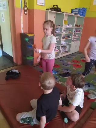 Dzieci bawią się na dywanie w przedszkolu.