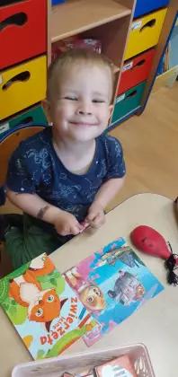 Chłopczyk ogląda książeczki.
 