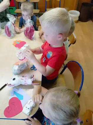 Maluszki wycinają serduszka dla taty.