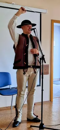 Góral Szczepan śpiewa do mikrofonu.