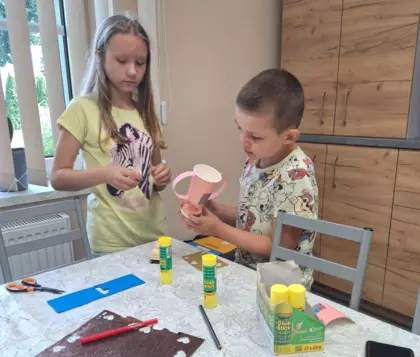 Chłopczyk i dziewczynka wykonują prezent na Dzień Taty.